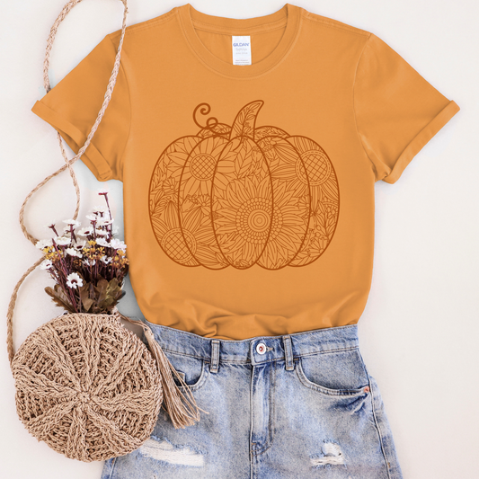 Mustard yellow t-shirt with pumpkin design, paired with denim shorts and a crochet bag on a white background.