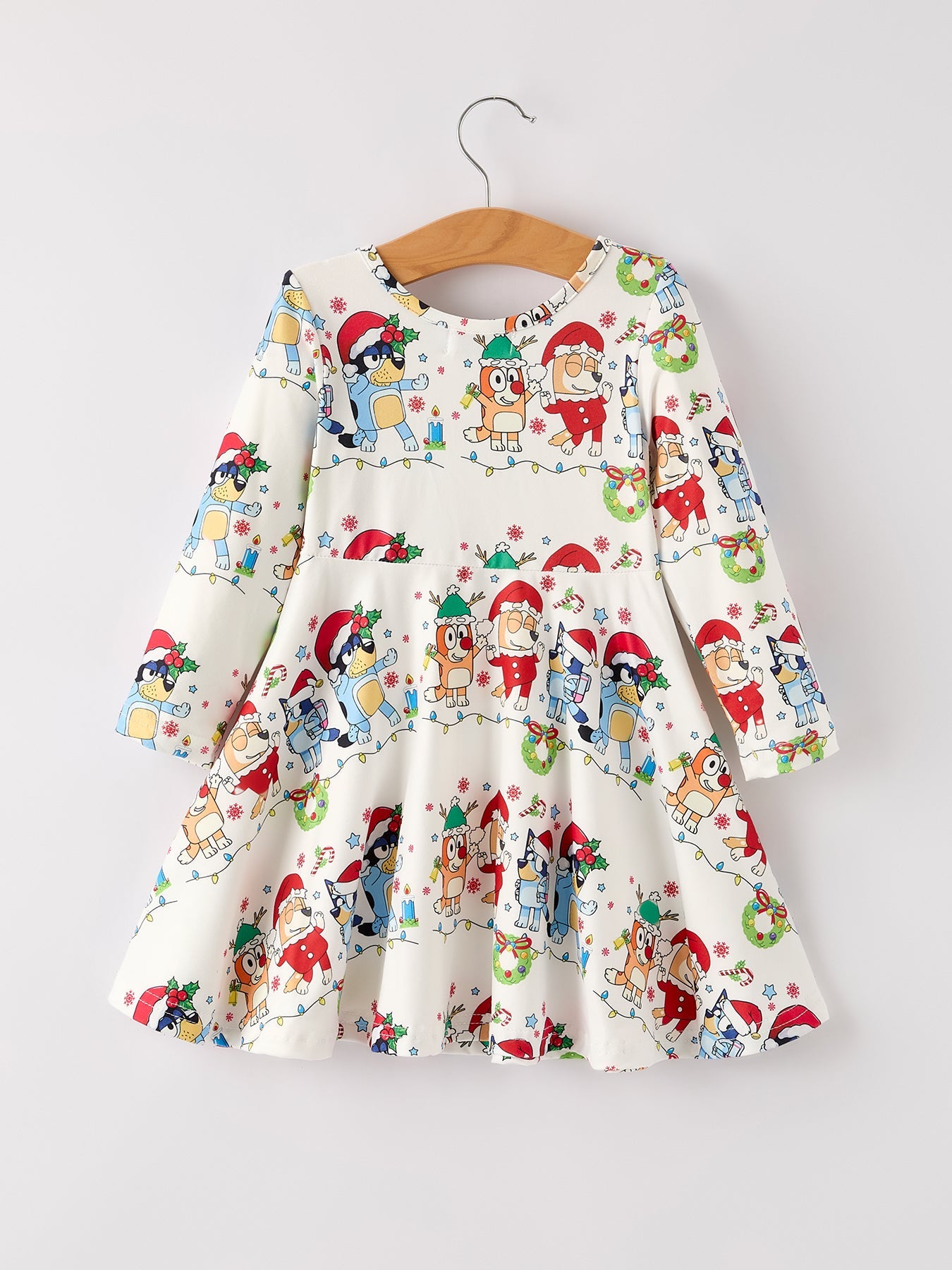 Children's dress with Christmas-themed pattern on a hanger against a white background