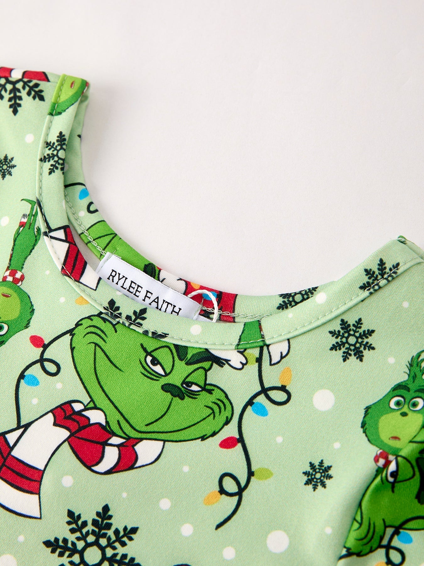 Children's outfit with Grinch design on a light green background