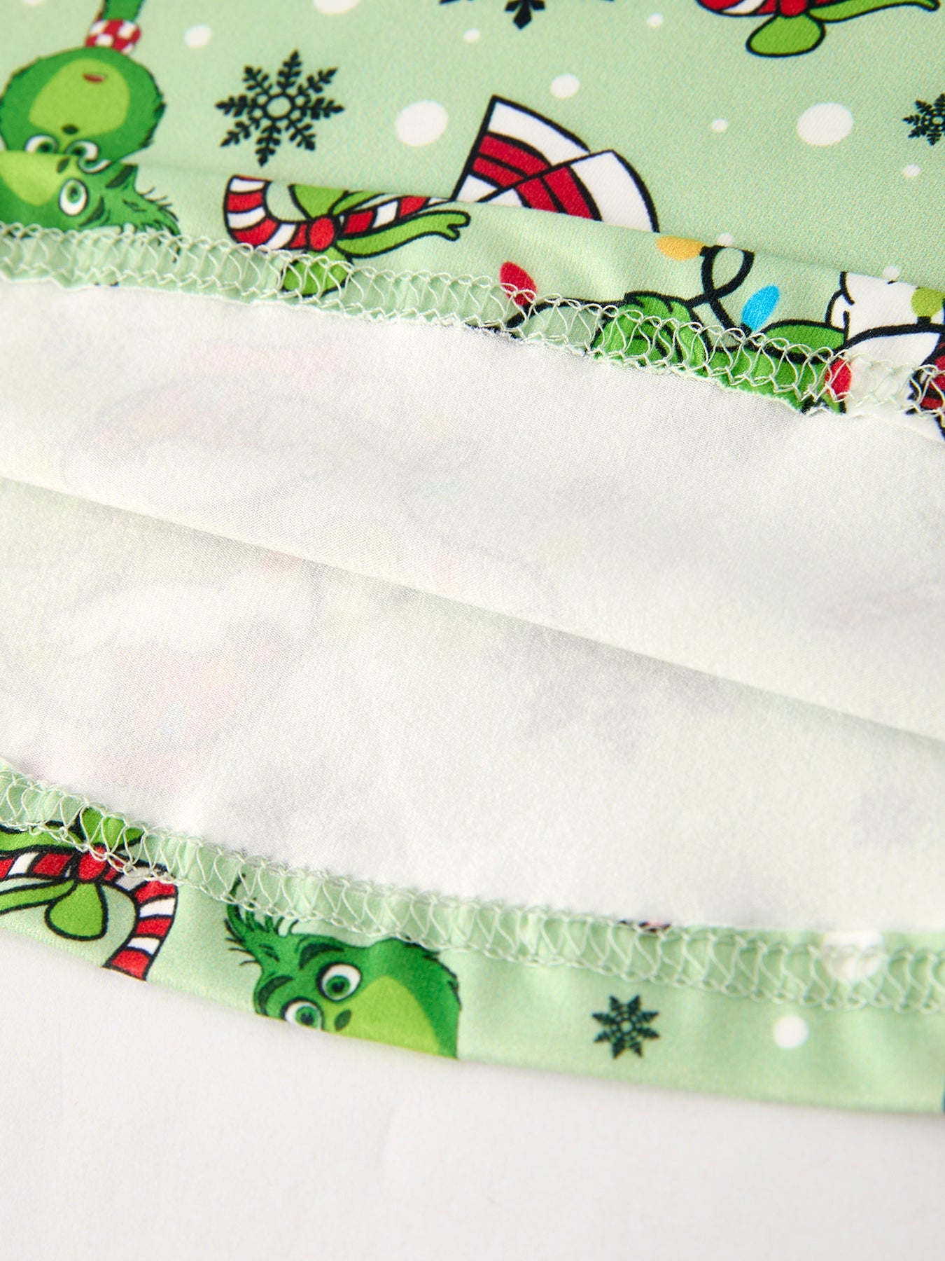 Close-up of a fabric strip with Christmas-themed designs on a white background