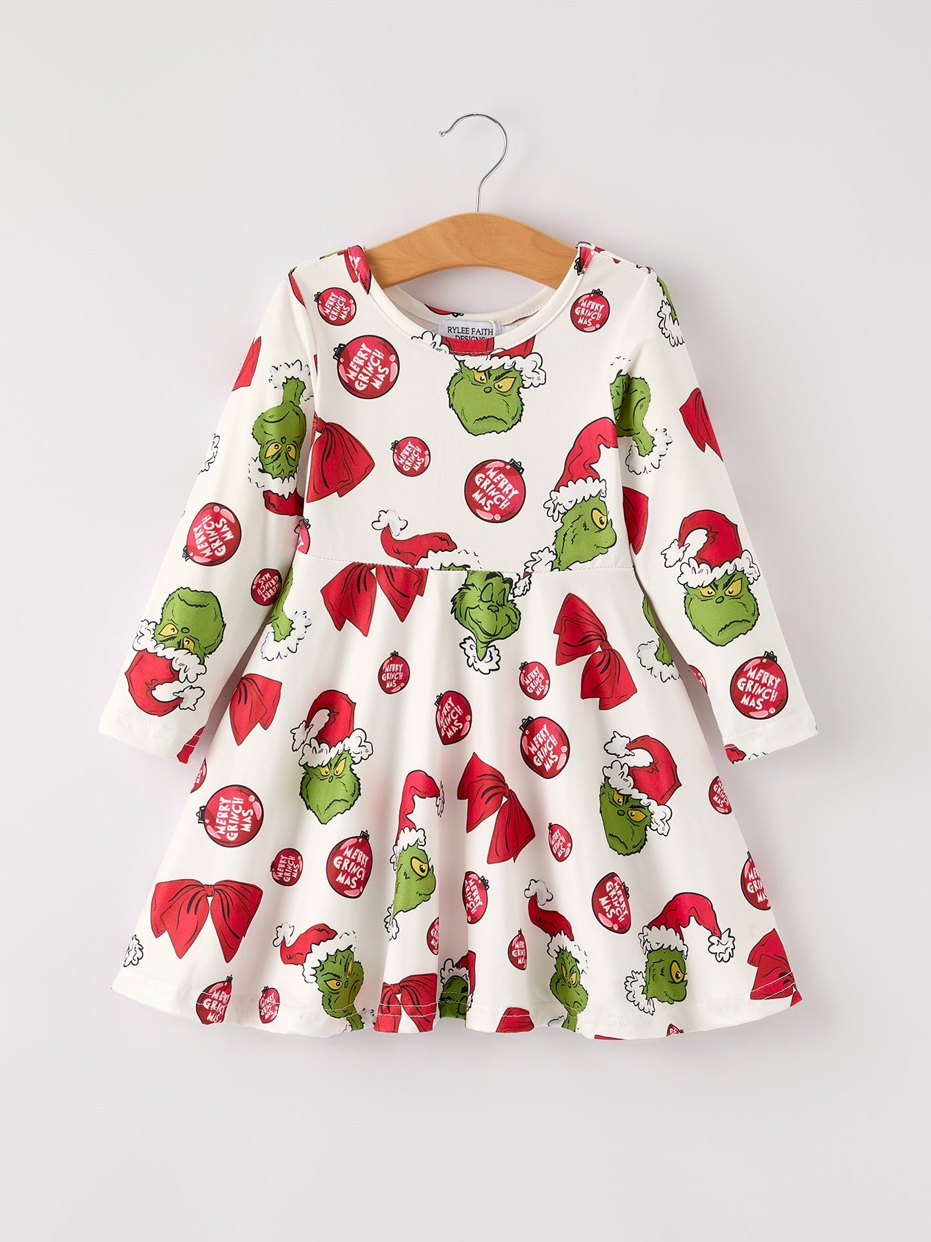 Children's dress with Grinch pattern on a hanger against a white background