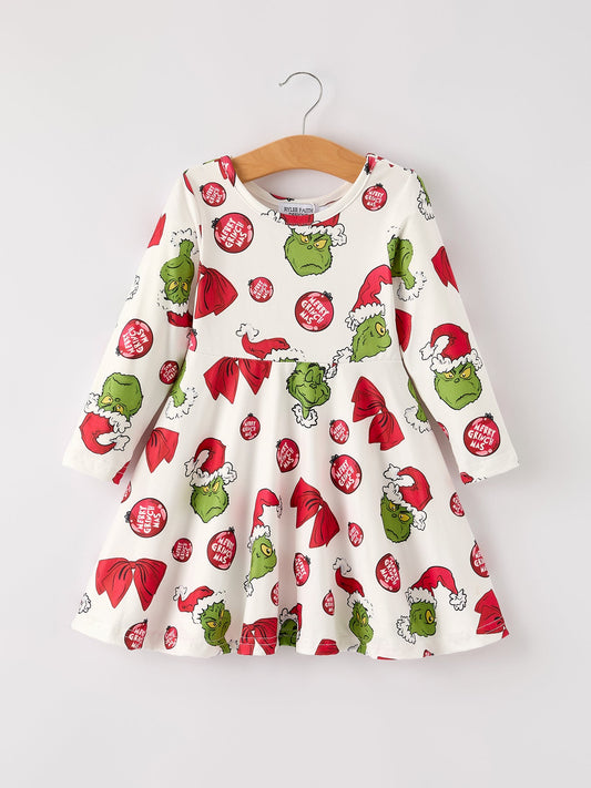 Children's dress with Grinch pattern on a hanger against a white background