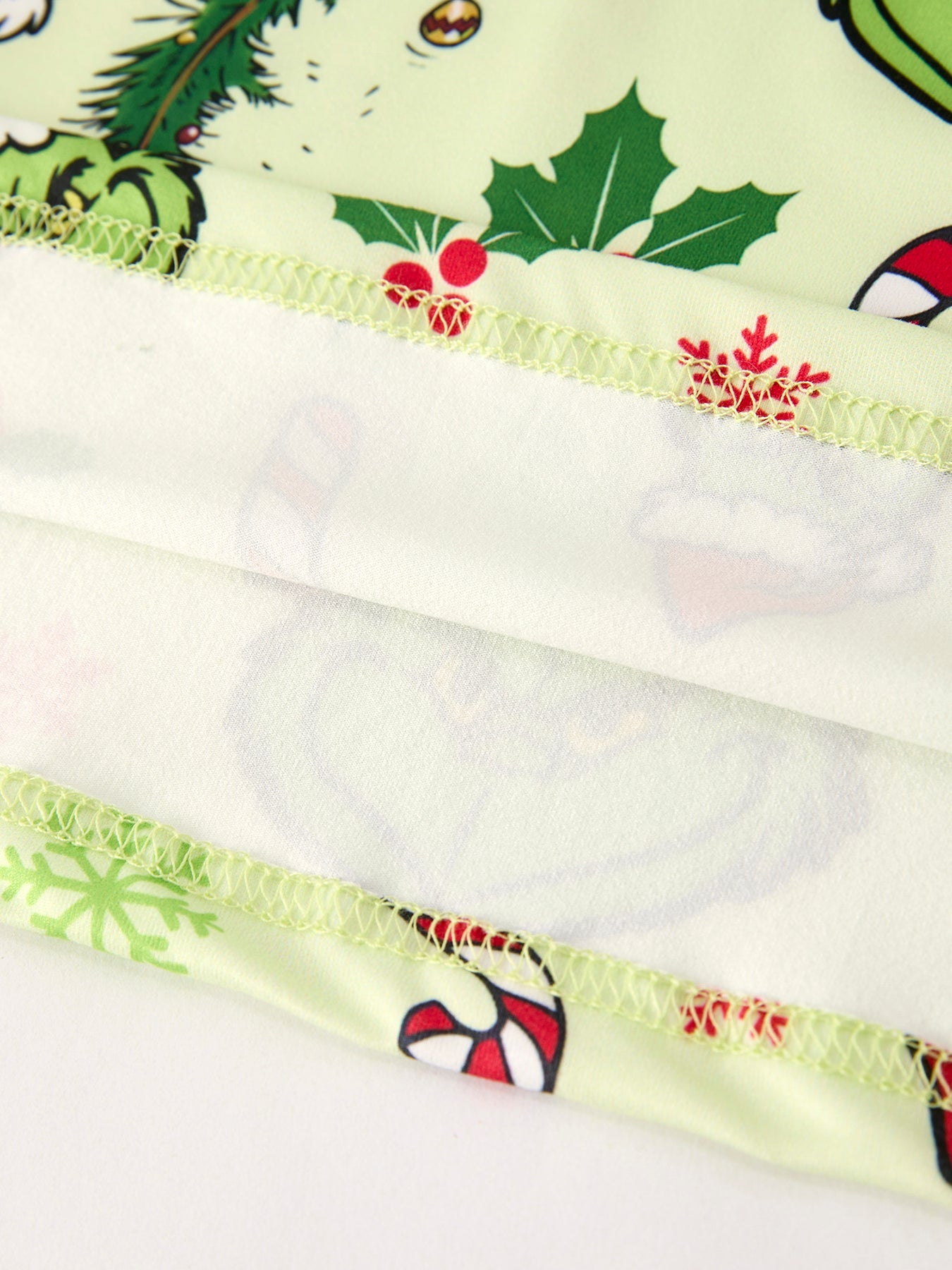 Close-up of a fabric strip with Christmas-themed pattern on a white background