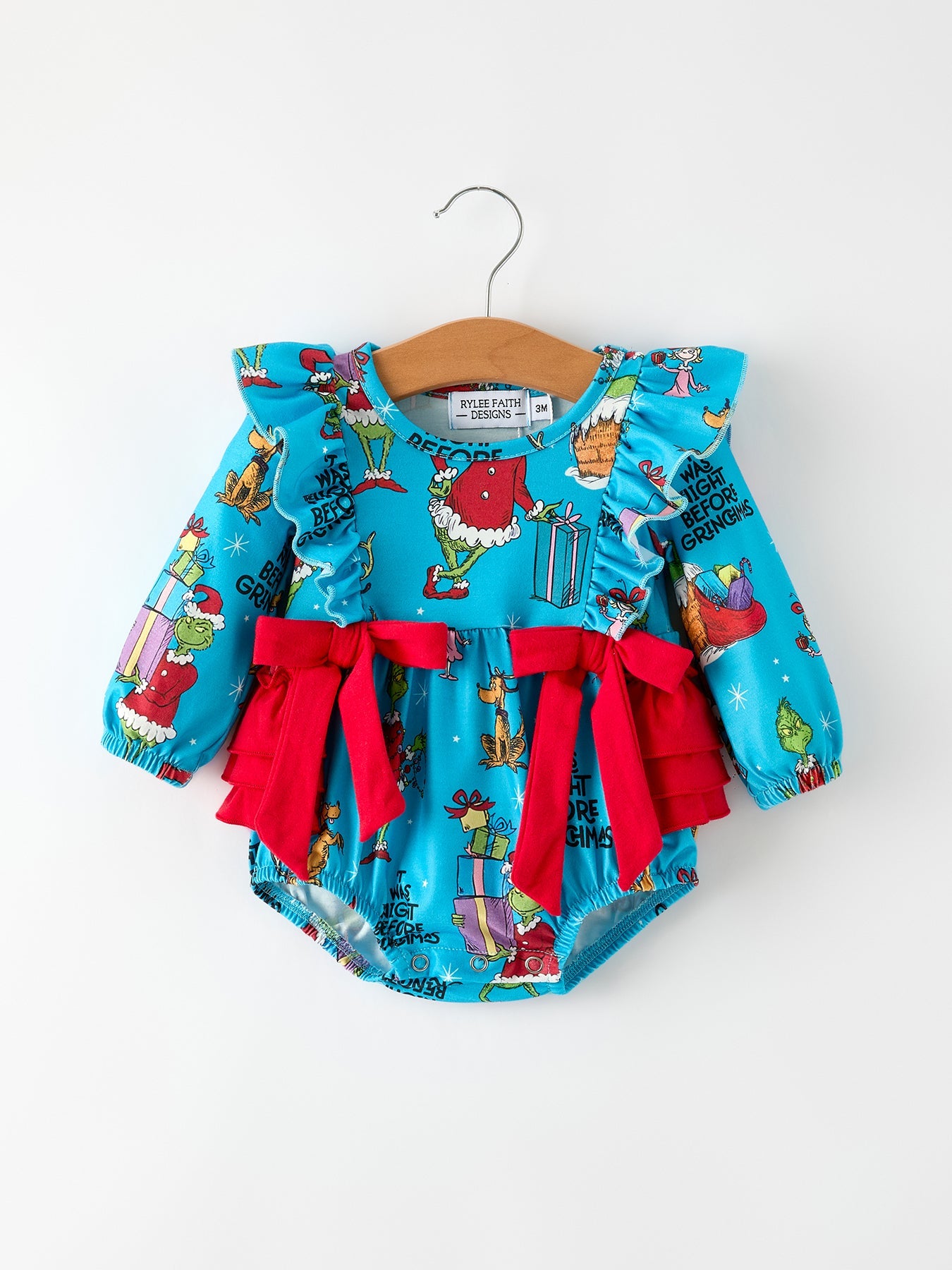 Baby romper with festive design and red bows on a white background