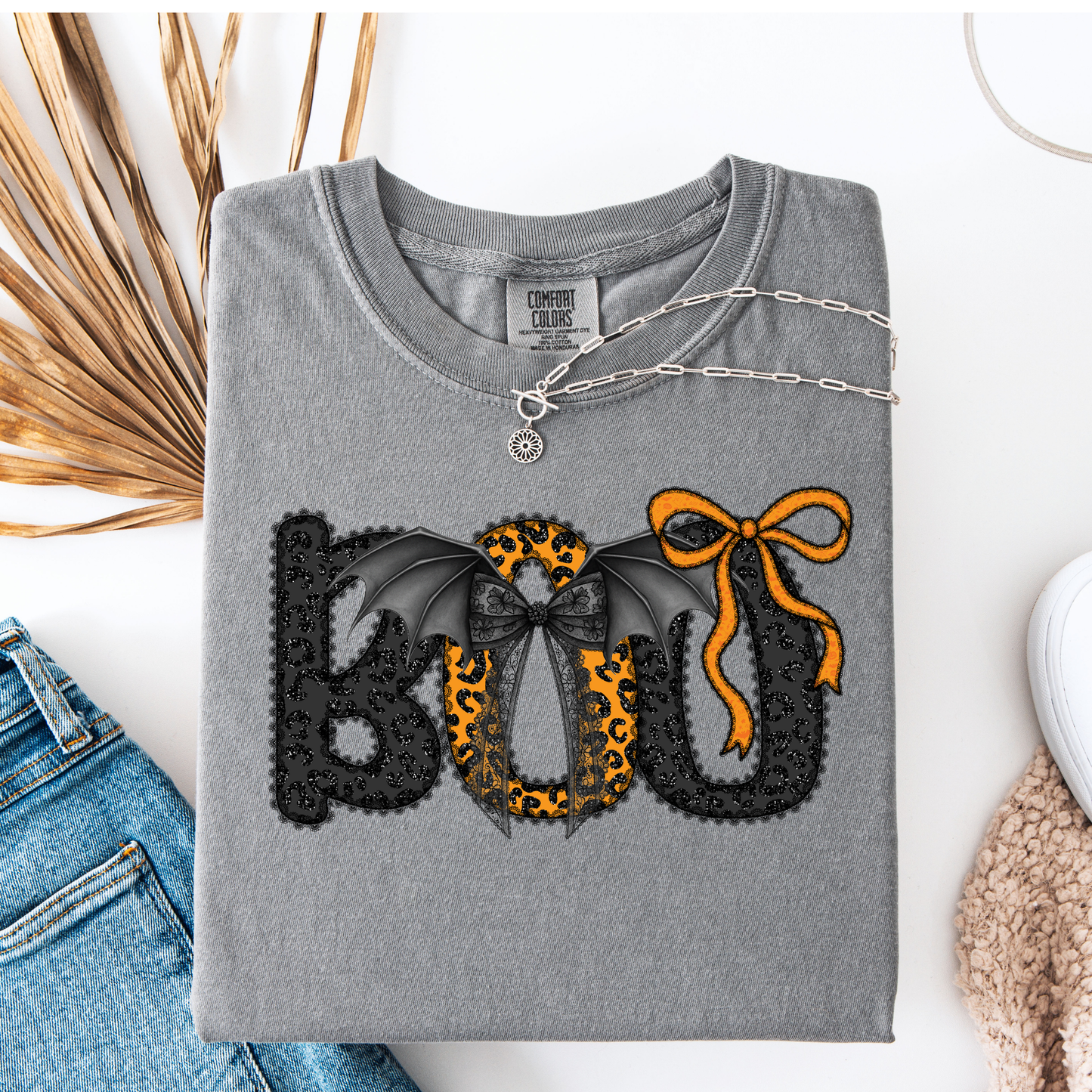 Gray t-shirt with decorative text and designs on a white surface