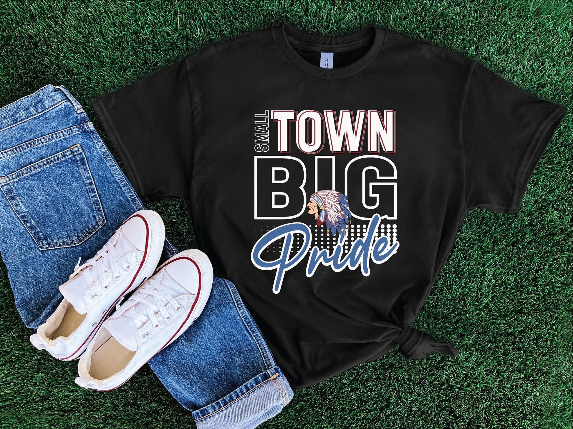 Black t-shirt with 'Small Town Big Pride' design on grass with jeans and shoes.