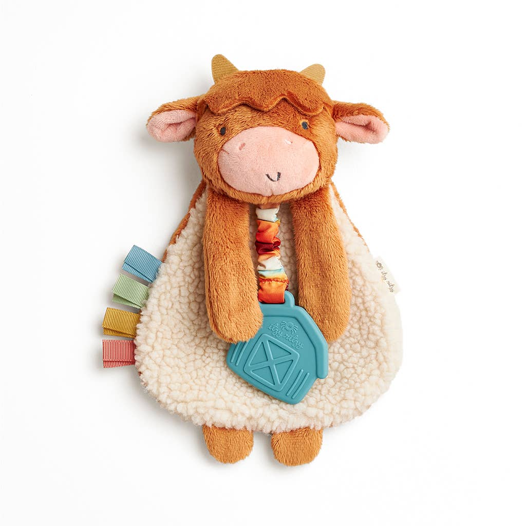 Plush cow toy with colorful elements on a white background