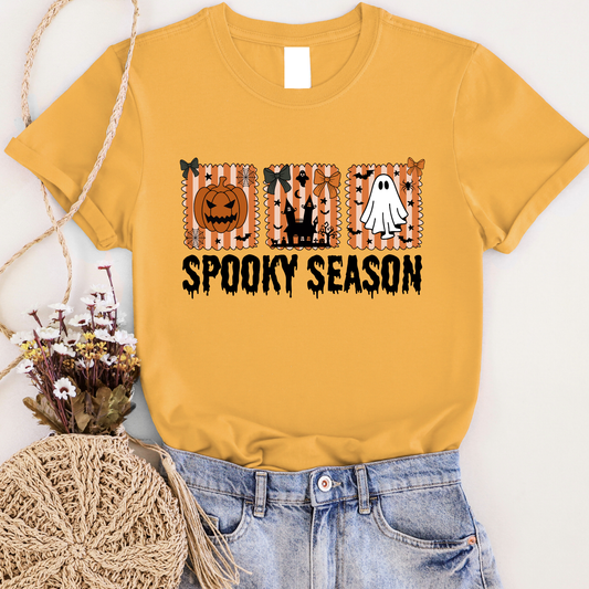 Yellow t-shirt with Halloween-themed design and 'Spooky Season' text, worn with jeans and a woven bag.