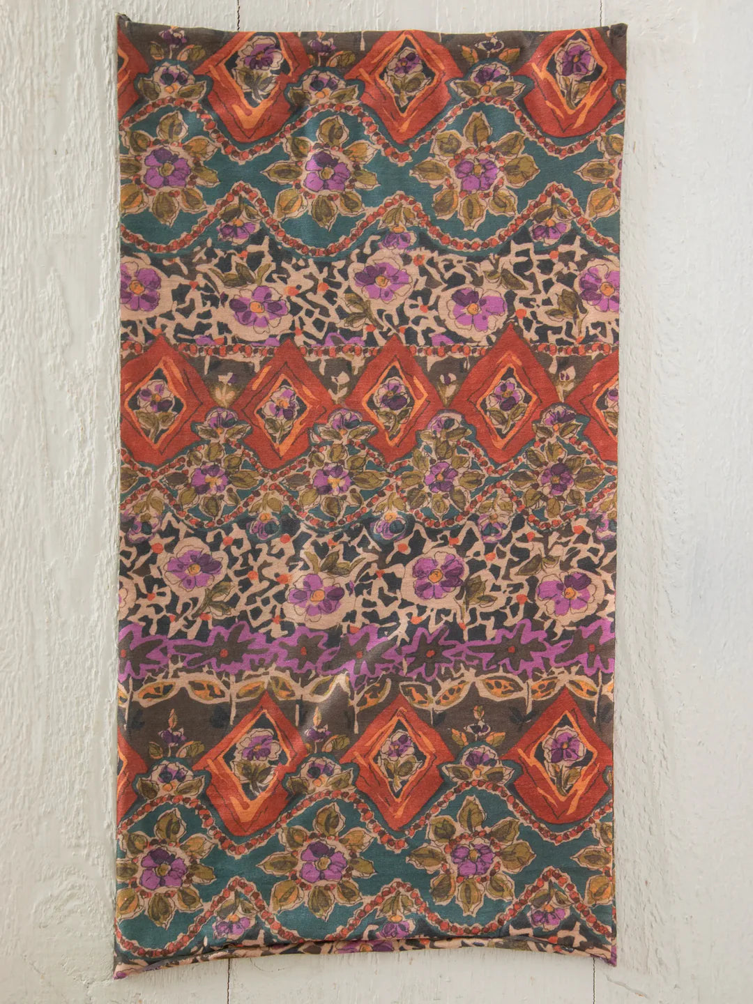 Decorative fabric with intricate pattern on a textured wall background