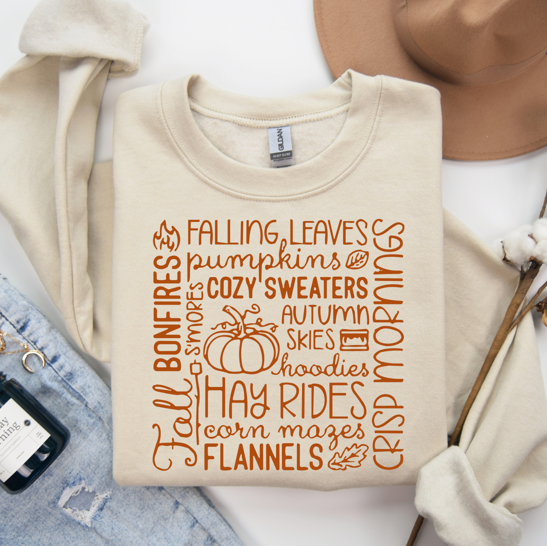 Beige sweatshirt with autumn-themed text and graphics on a white background