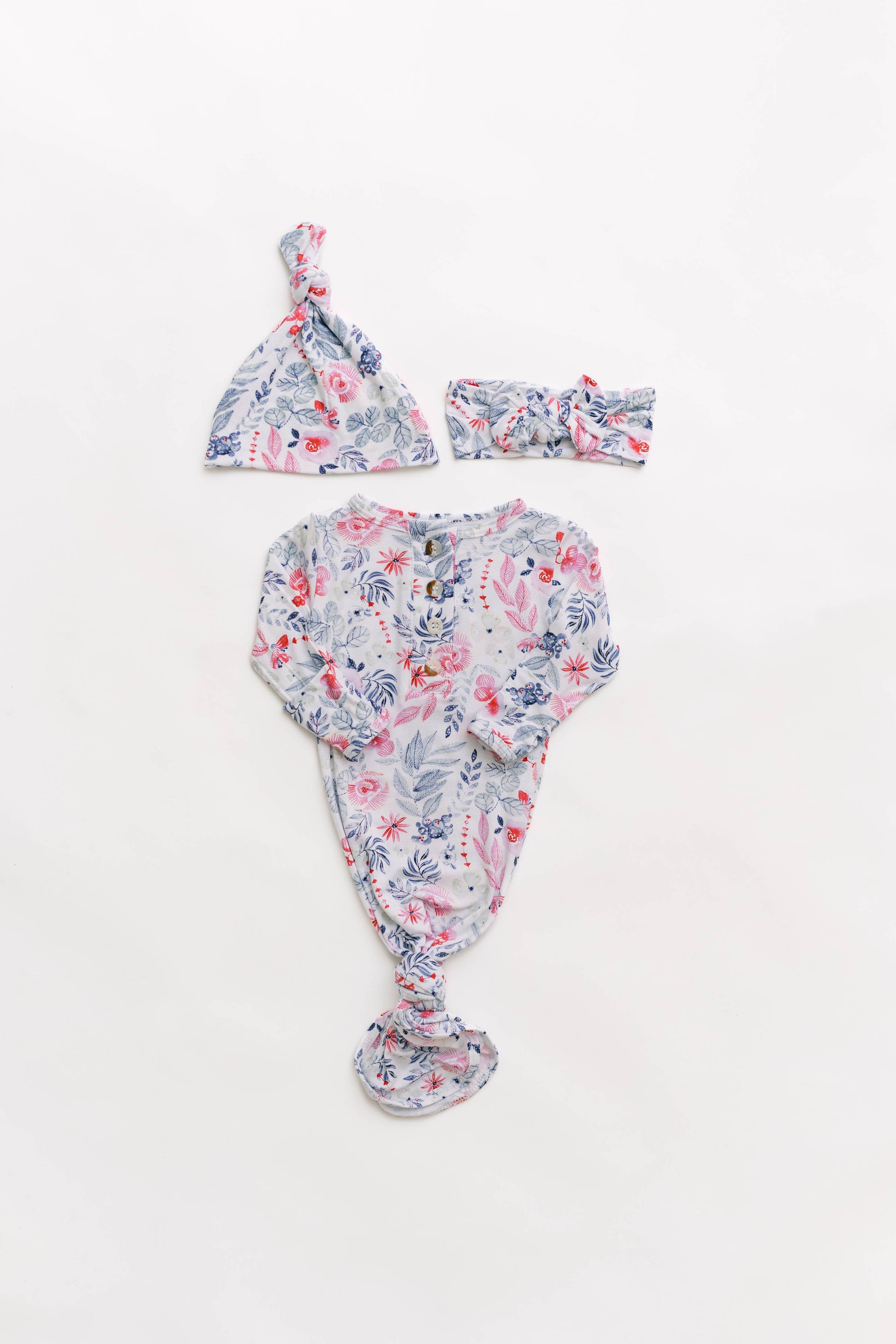 Floral baby outfit with hat and headband on a white background