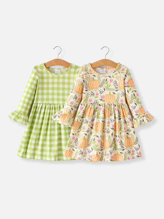 Two children's dresses on hangers against a white background