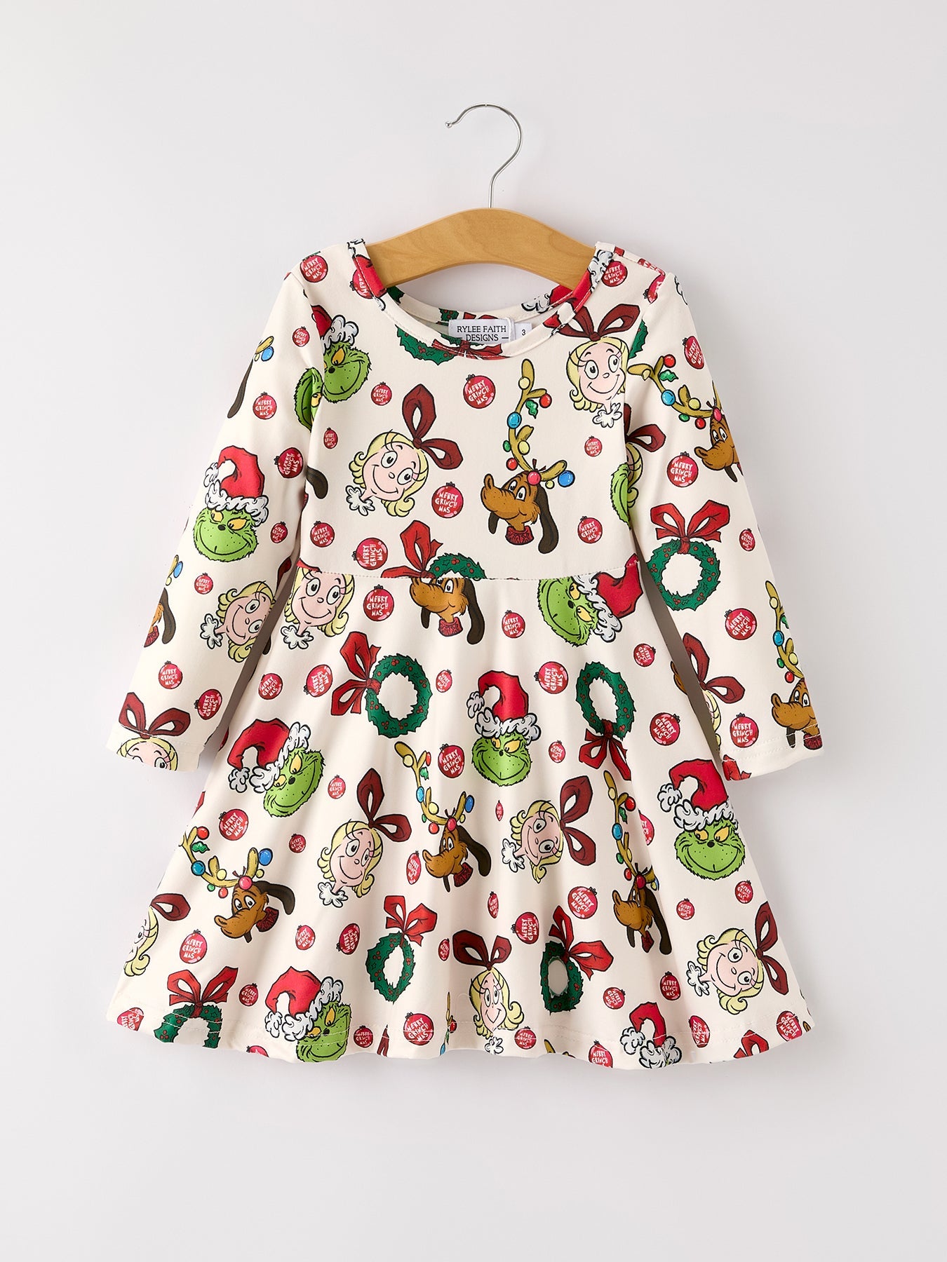 Children's dress with Christmas-themed pattern on a hanger against a white background