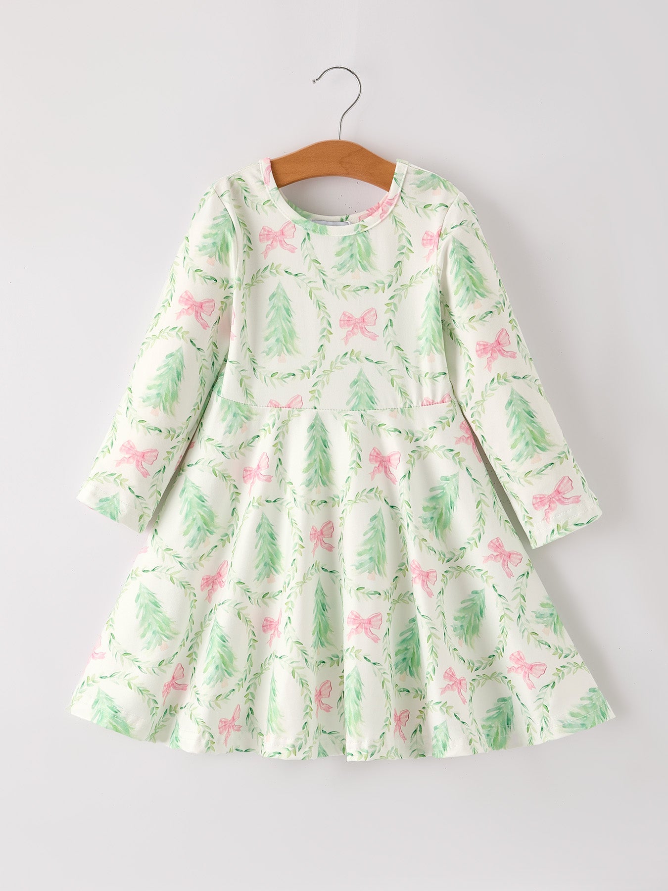 Green dress with pink floral pattern on a hanger against a white background