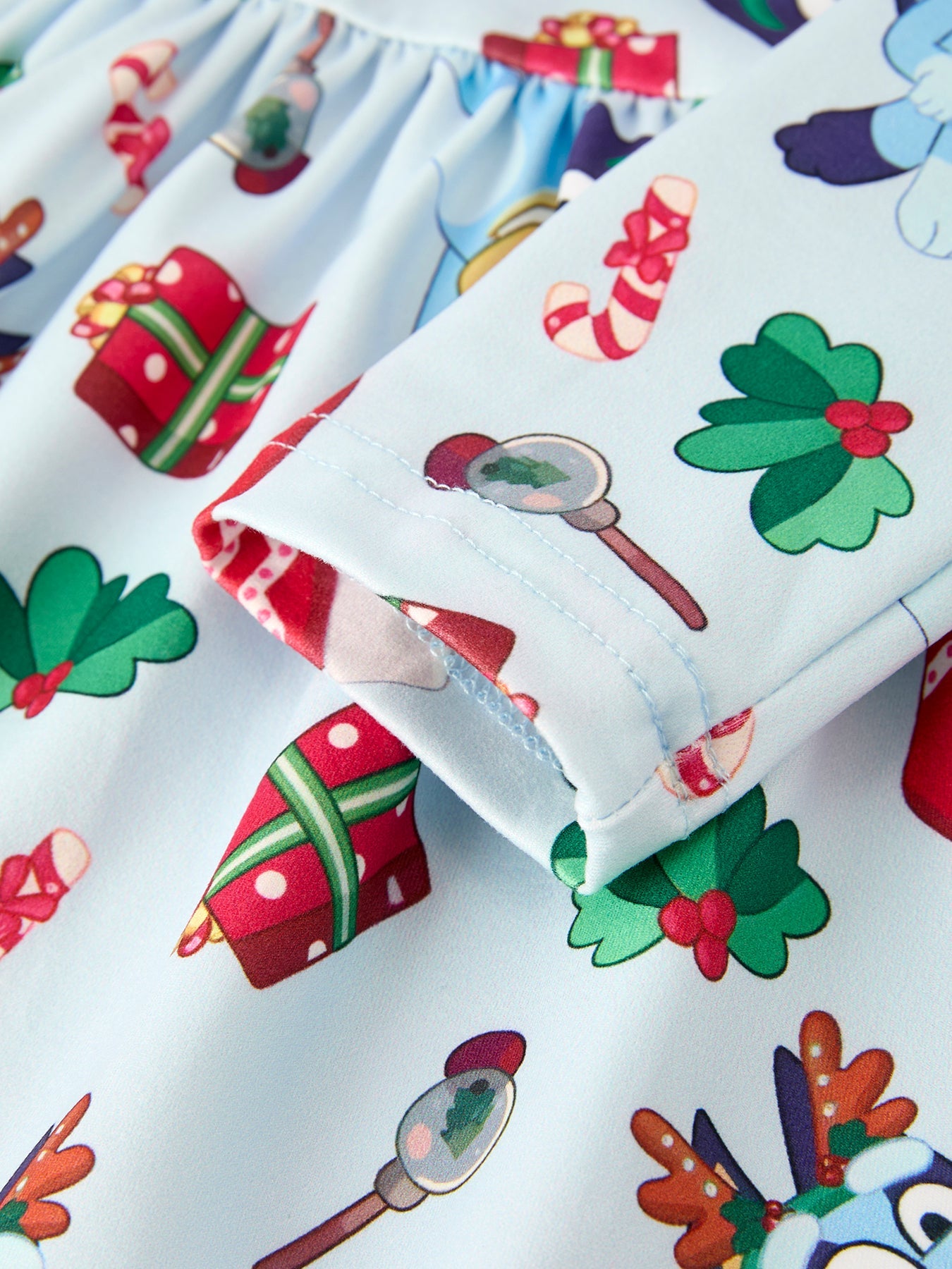 Colorful fabric with Christmas-themed patterns including presents, candy canes, and snowmen.
