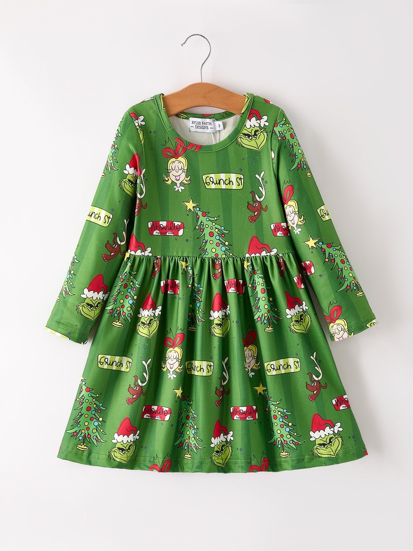 Green children's dress with Christmas-themed print on a white background
