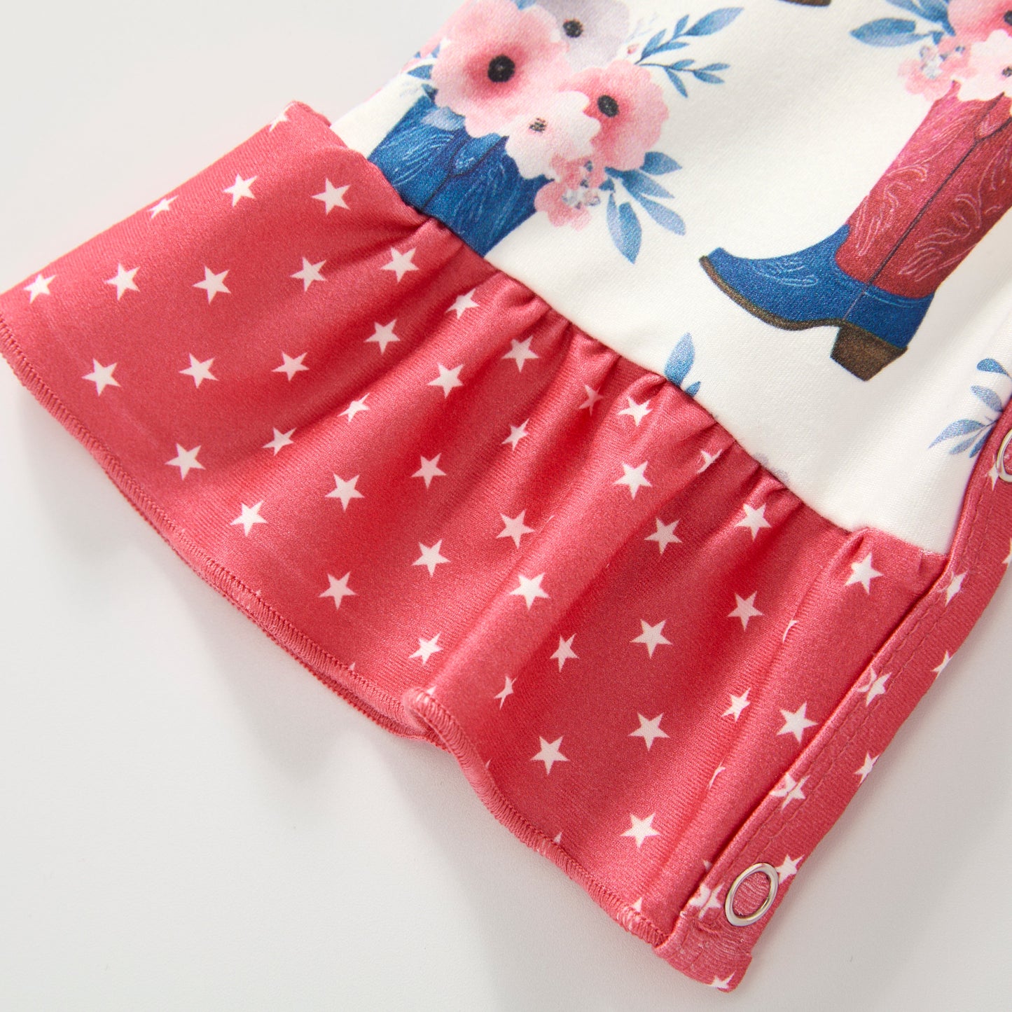 Children's  infant romper with red star pattern and floral design on a white background