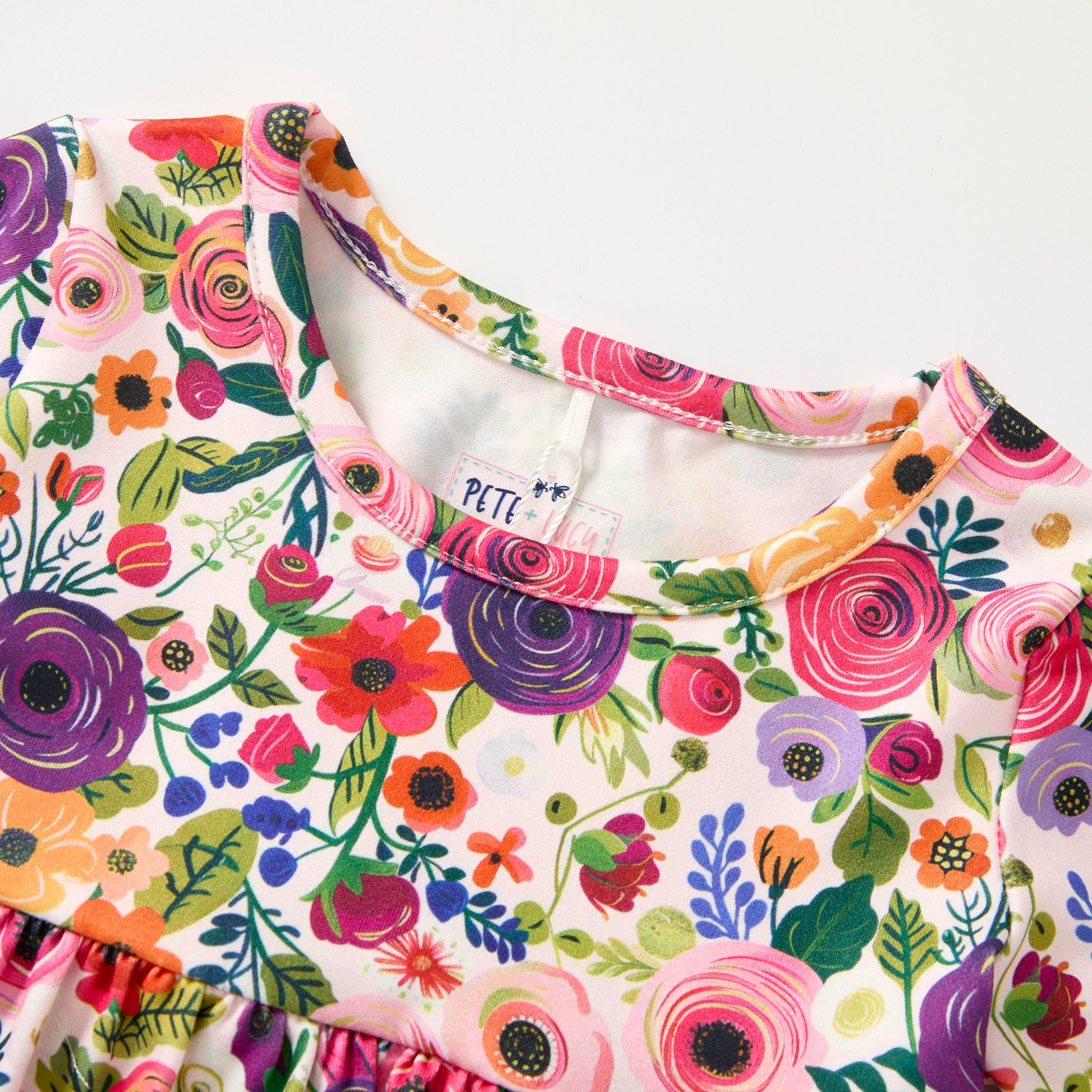 Colorful floral-patterned garment with 'Petti' label on a white background