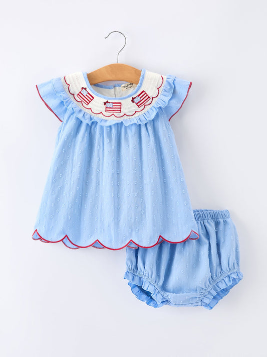 Light blue baby dress with red trim and matching bloomers on a white background