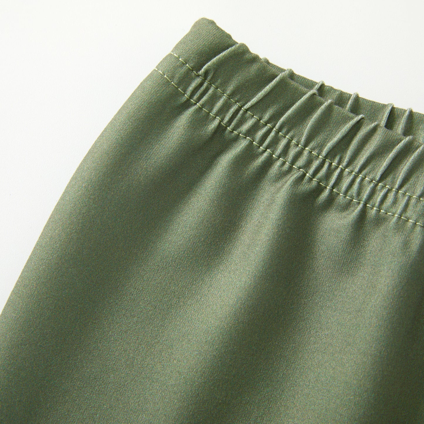 Close-up of green pants with an elastic waistband on a white background