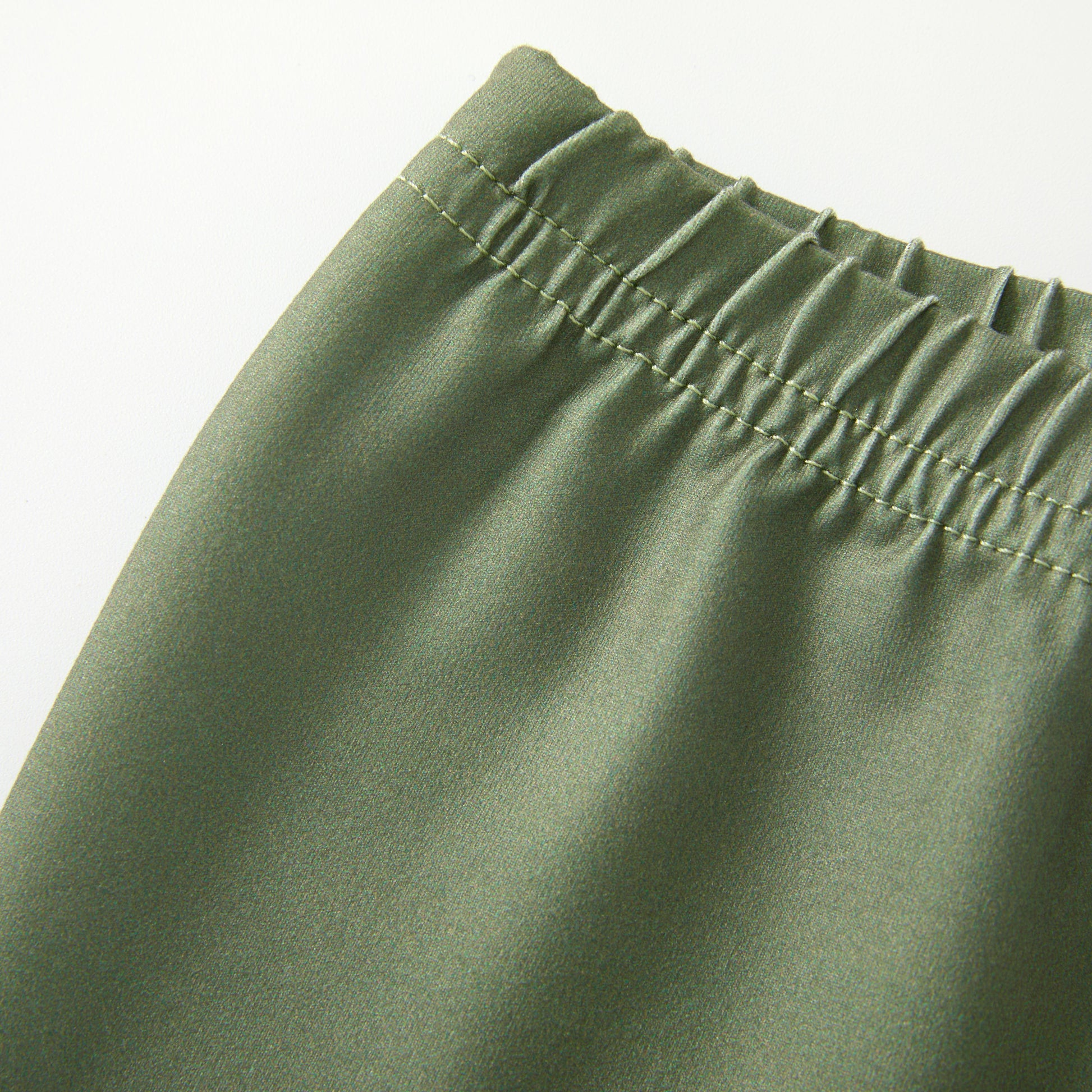 Close-up of green pants with an elastic waistband on a white background