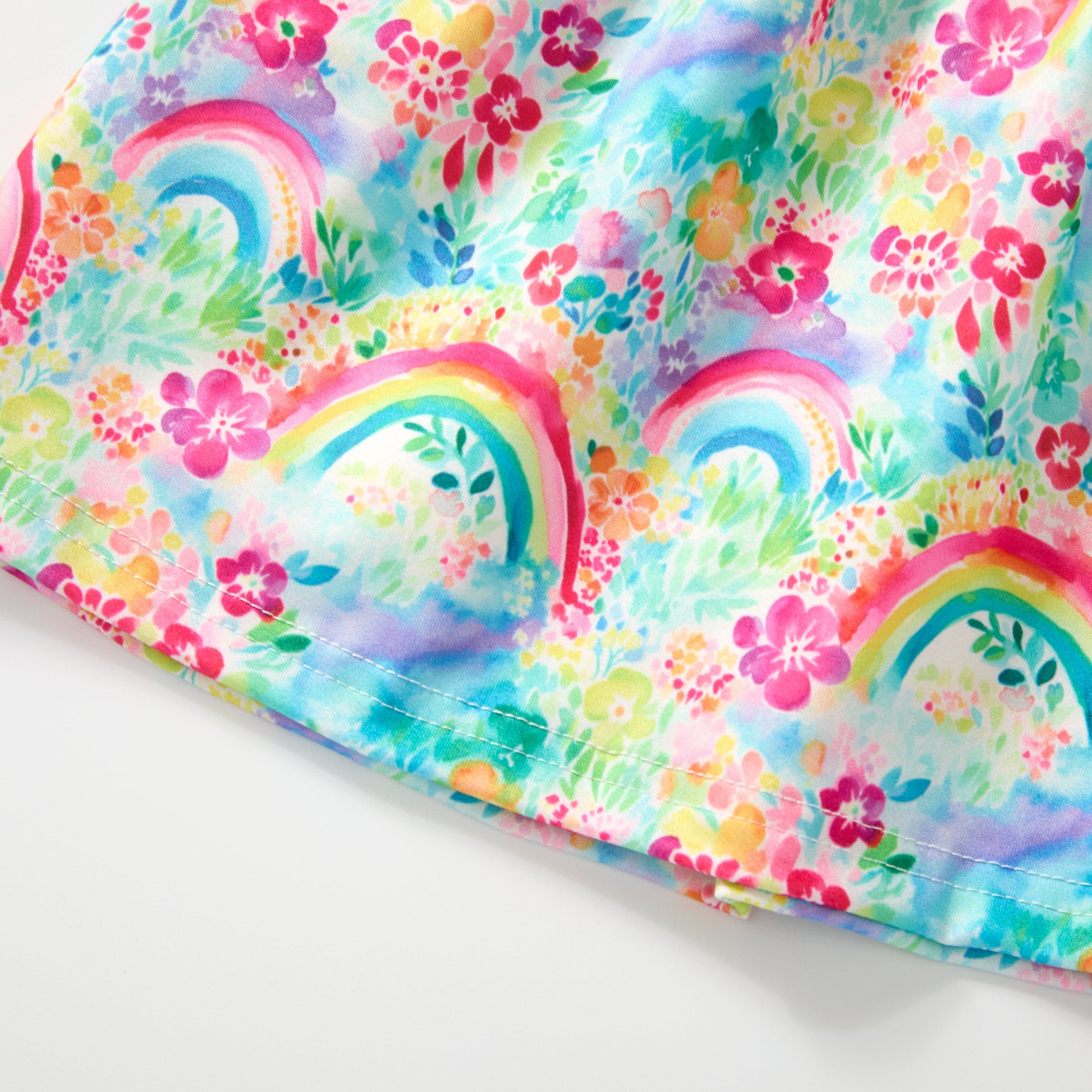 Colorful fabric with rainbow and floral patterns on a white background