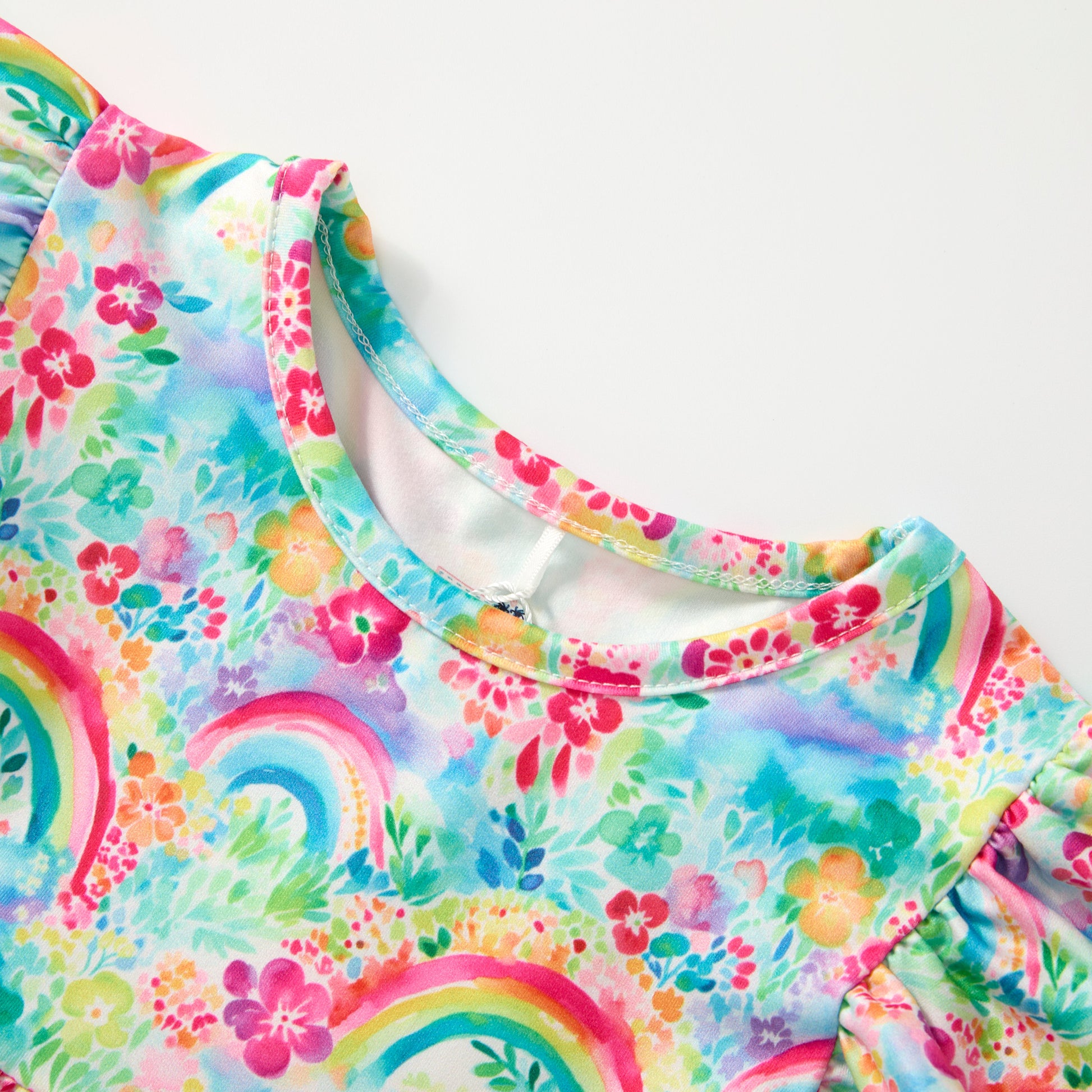 Colorful children's swimsuit with floral and rainbow patterns on a white background
