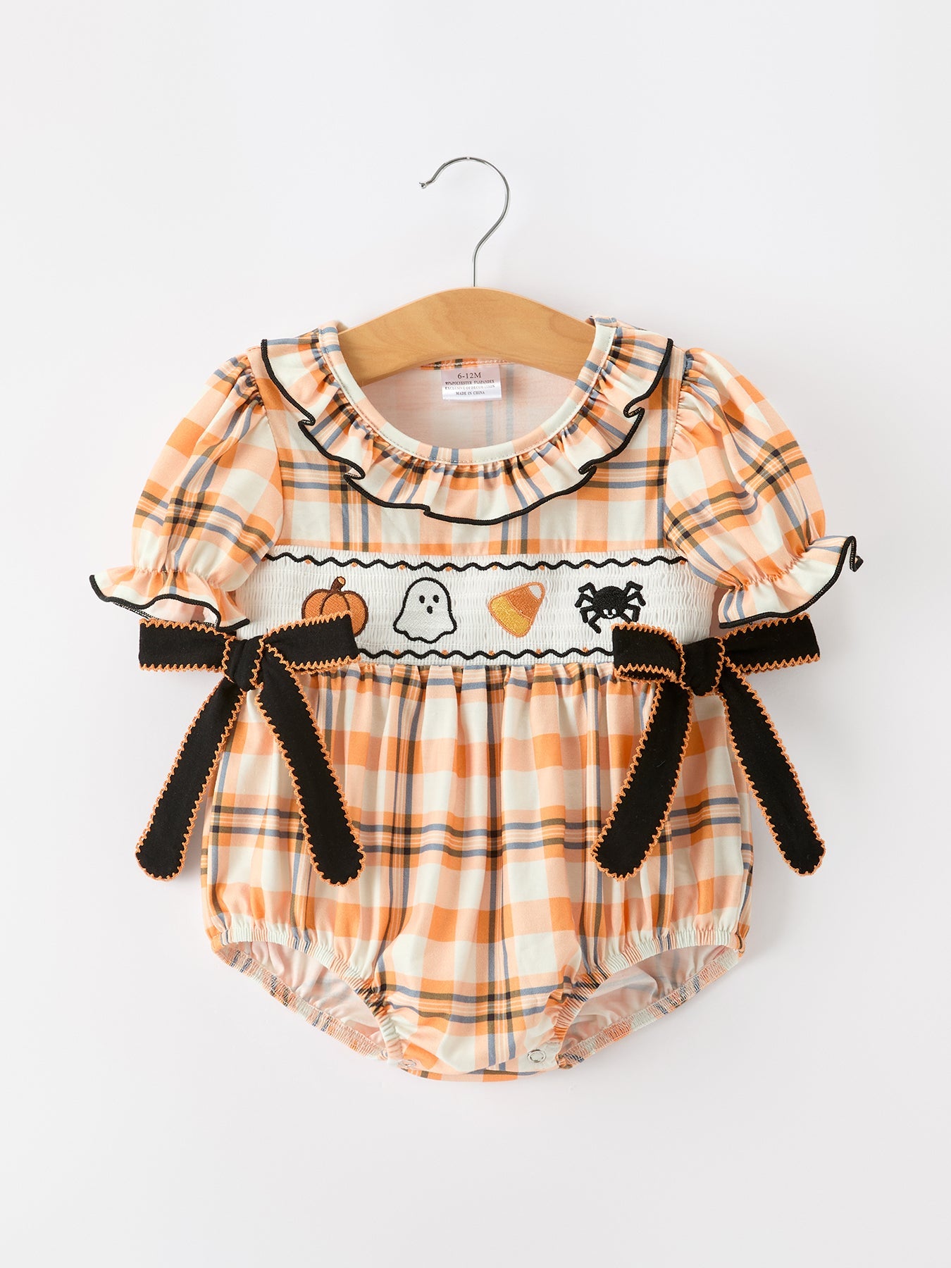 Baby romper with Halloween-themed design on a hanger against a white background