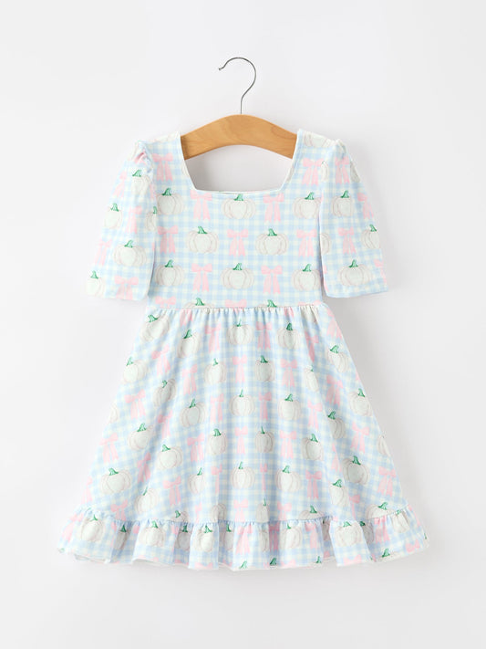 Checkered dress with pineapple pattern on a hanger against a white background