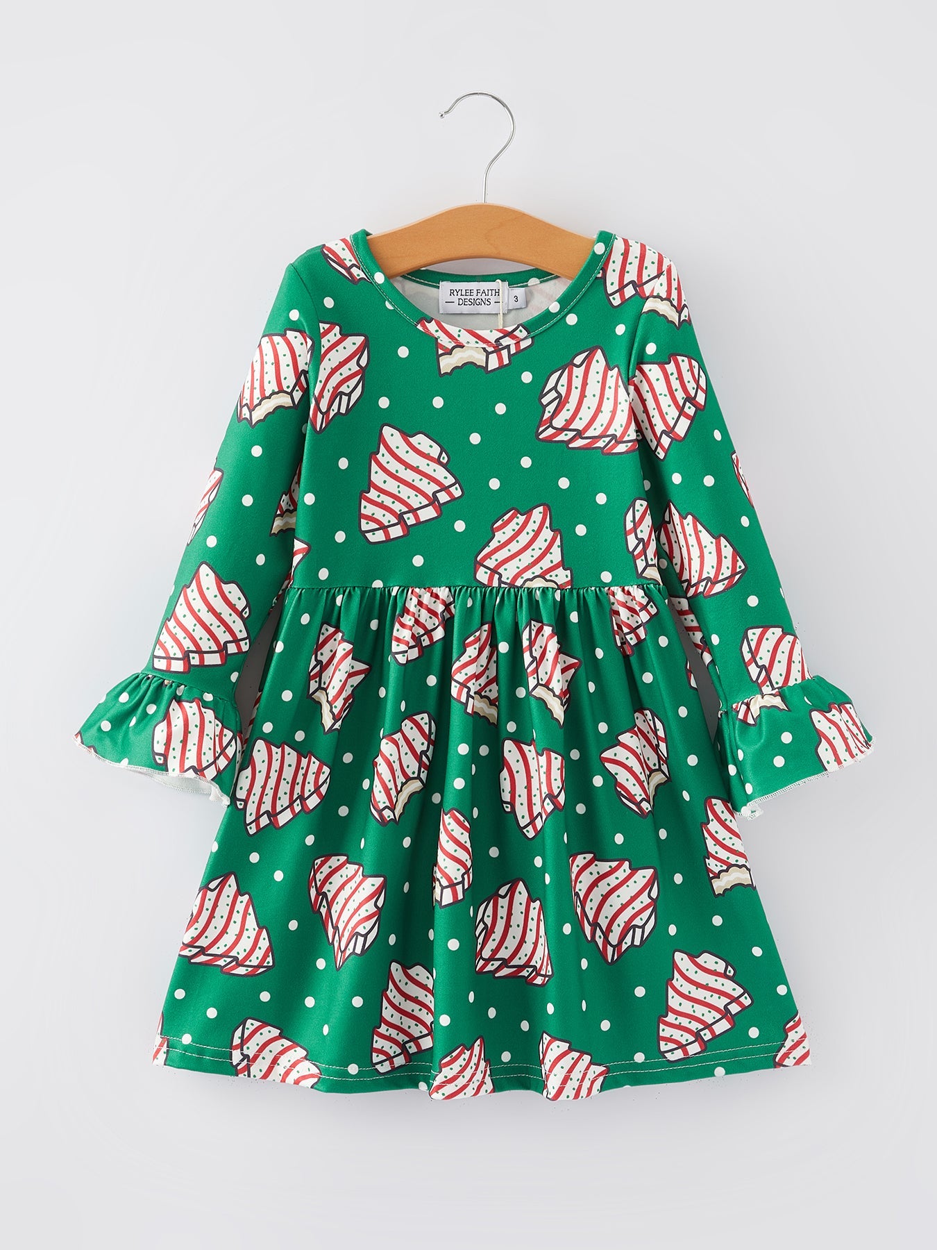 Green dress with red and white pattern on a hanger against a white background