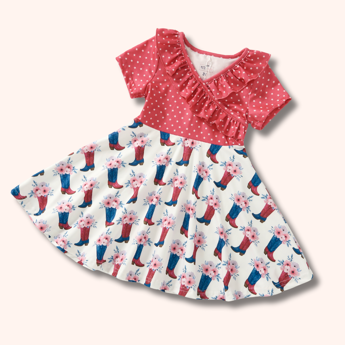 Children's dress with pink polka dot top and floral cowboy boot skirt on a white background