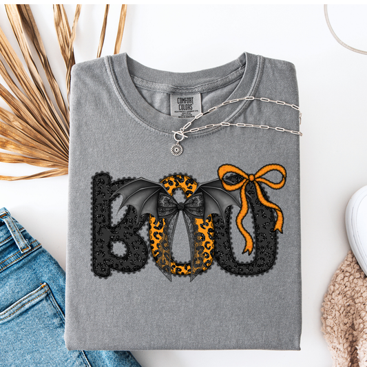 Gray t-shirt with decorative text and designs on a white surface