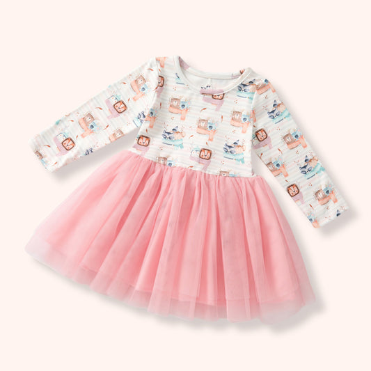 A toddler girl's long-sleeve dress with a white printed bodice featuring cartoon characters and a fluffy pink tulle skirt, shown on a light cream background.