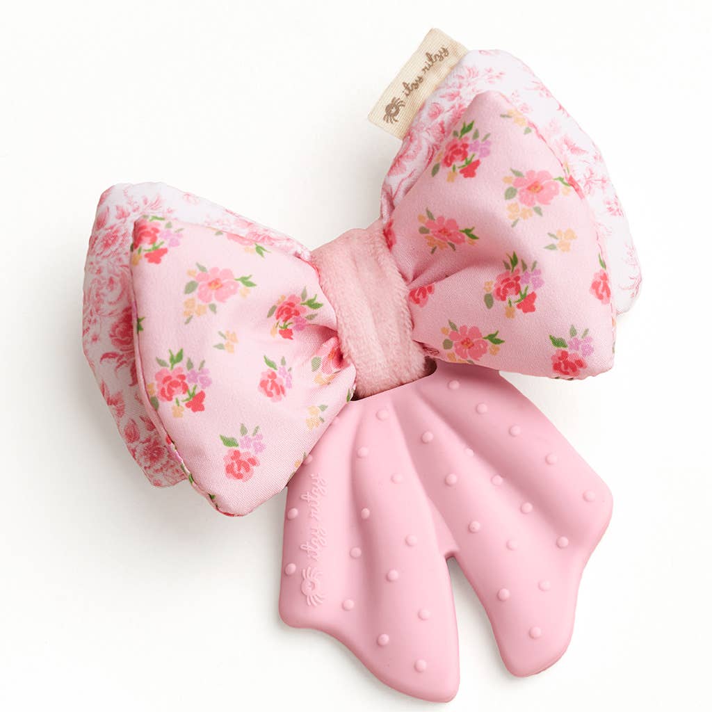 Floral-patterned bow with pink polka dot tail on a white background