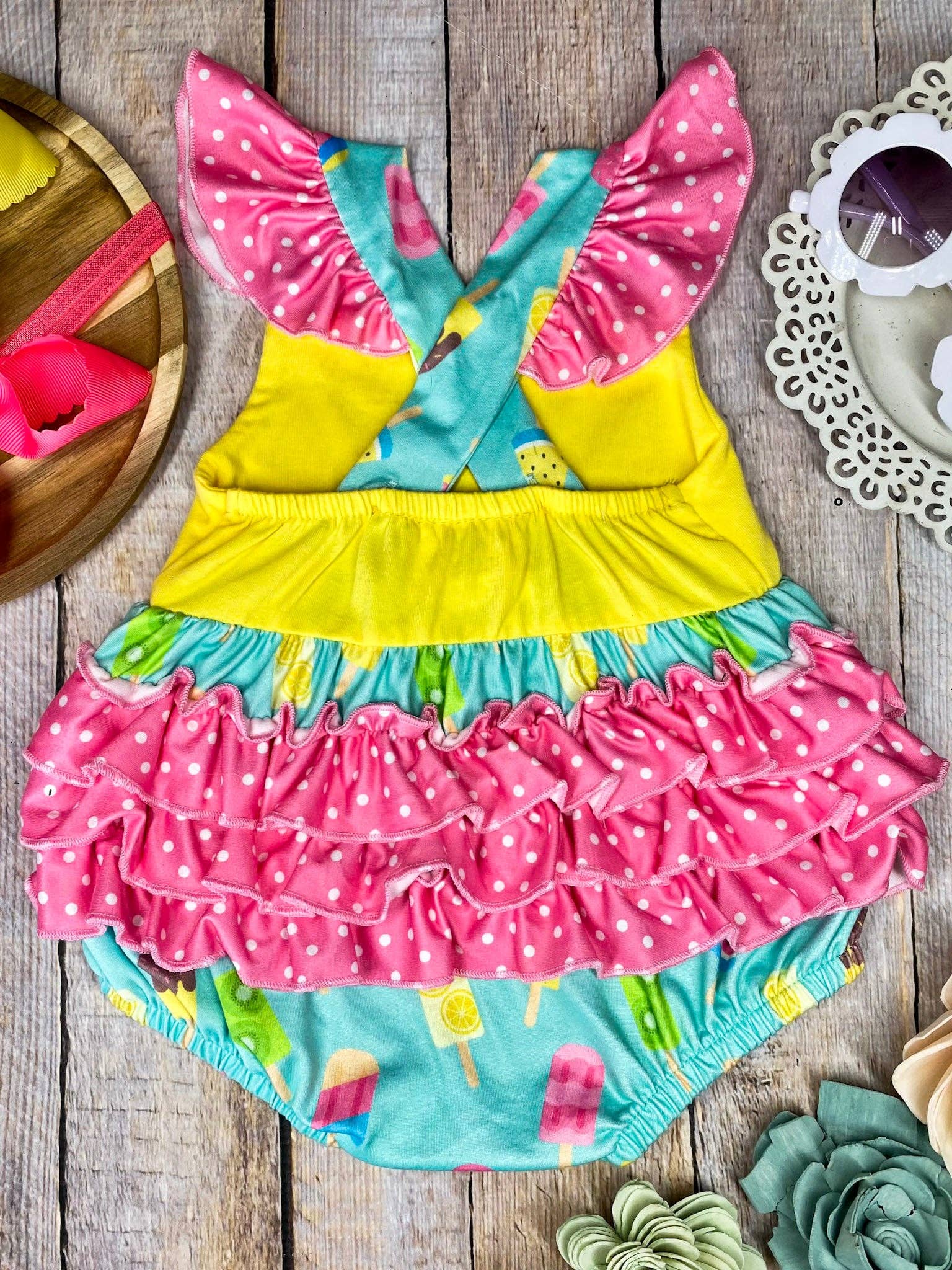Colorful children's outfit with ruffles on a wooden surface
