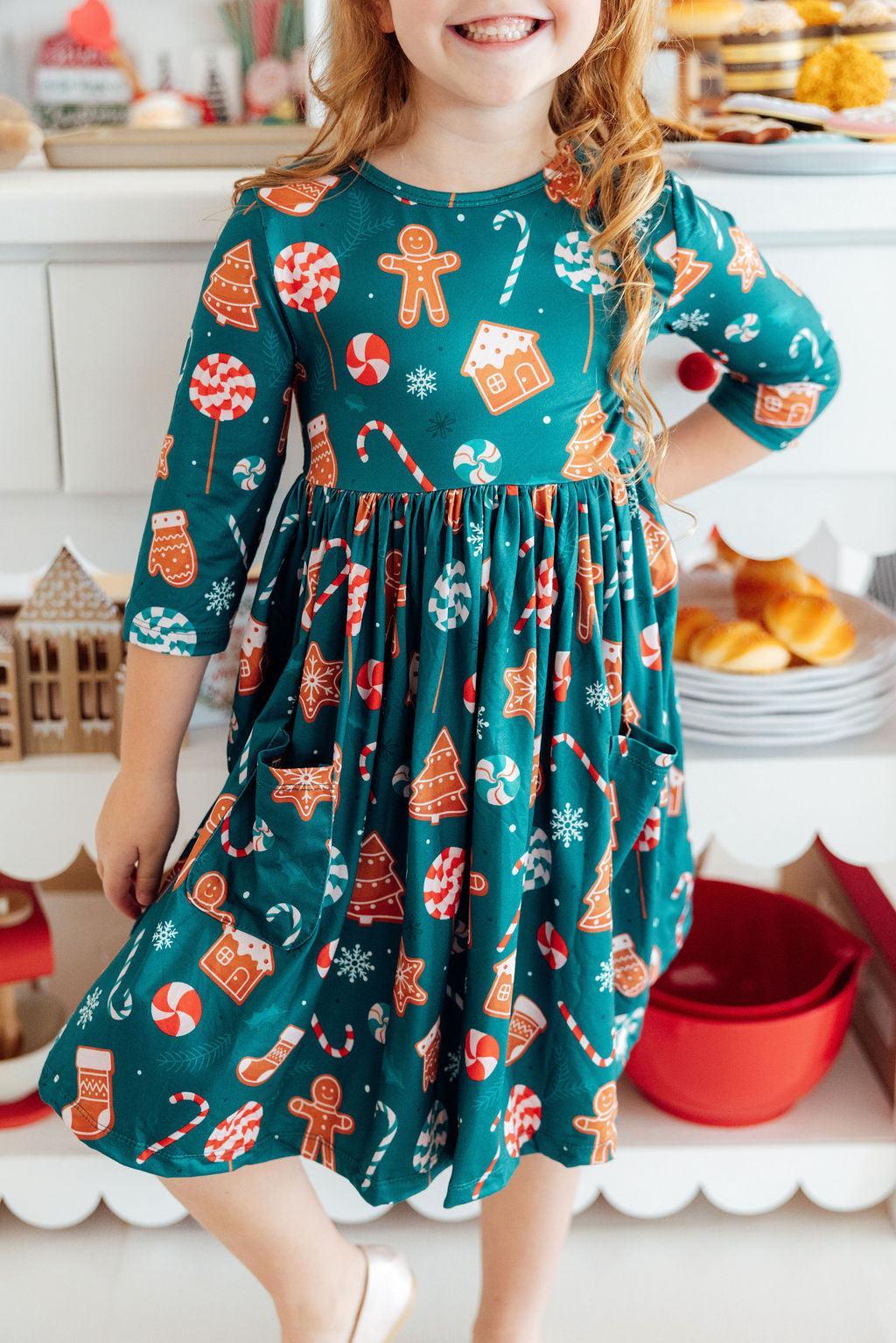 Girl in a gingerbread themed dress. Kitchen-like backdrop. 