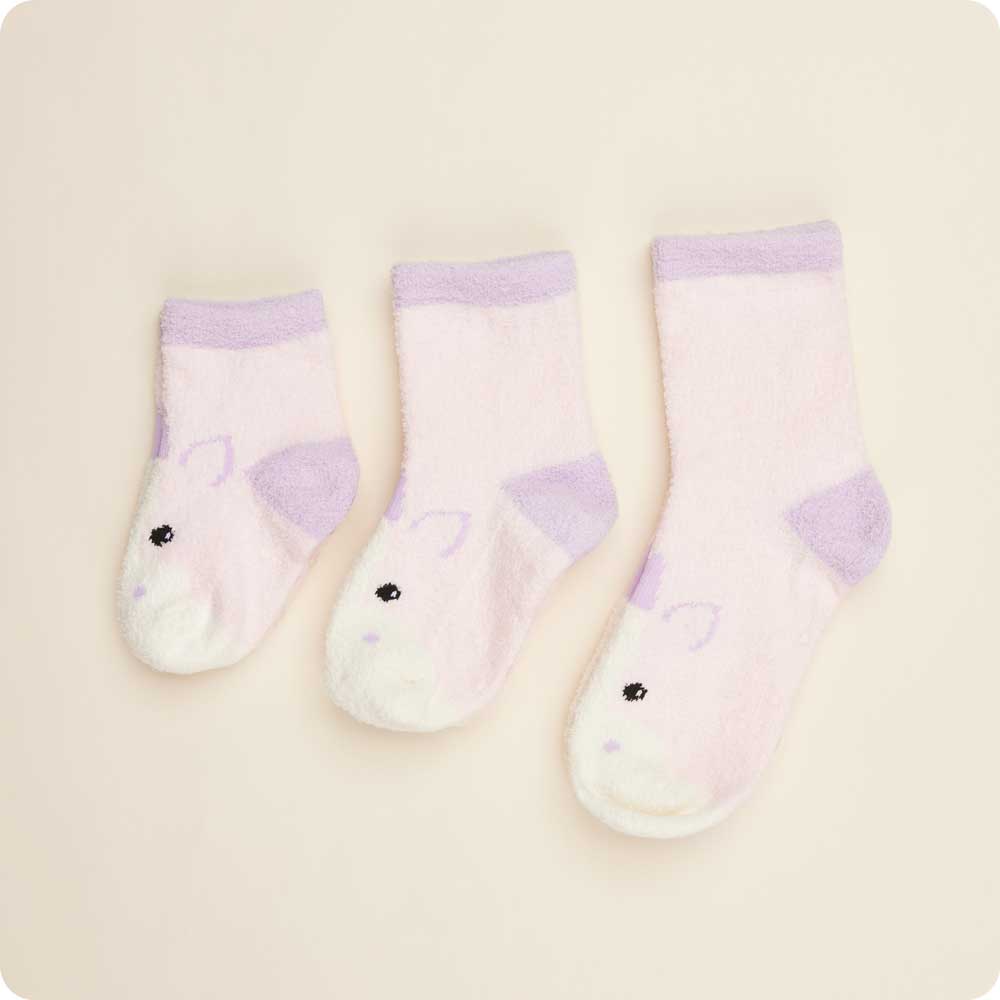 Set of three baby socks with animal faces on a beige background
