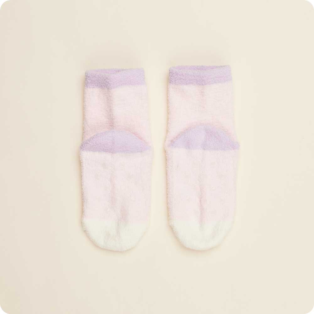 Pair of baby socks with purple accents on a beige background