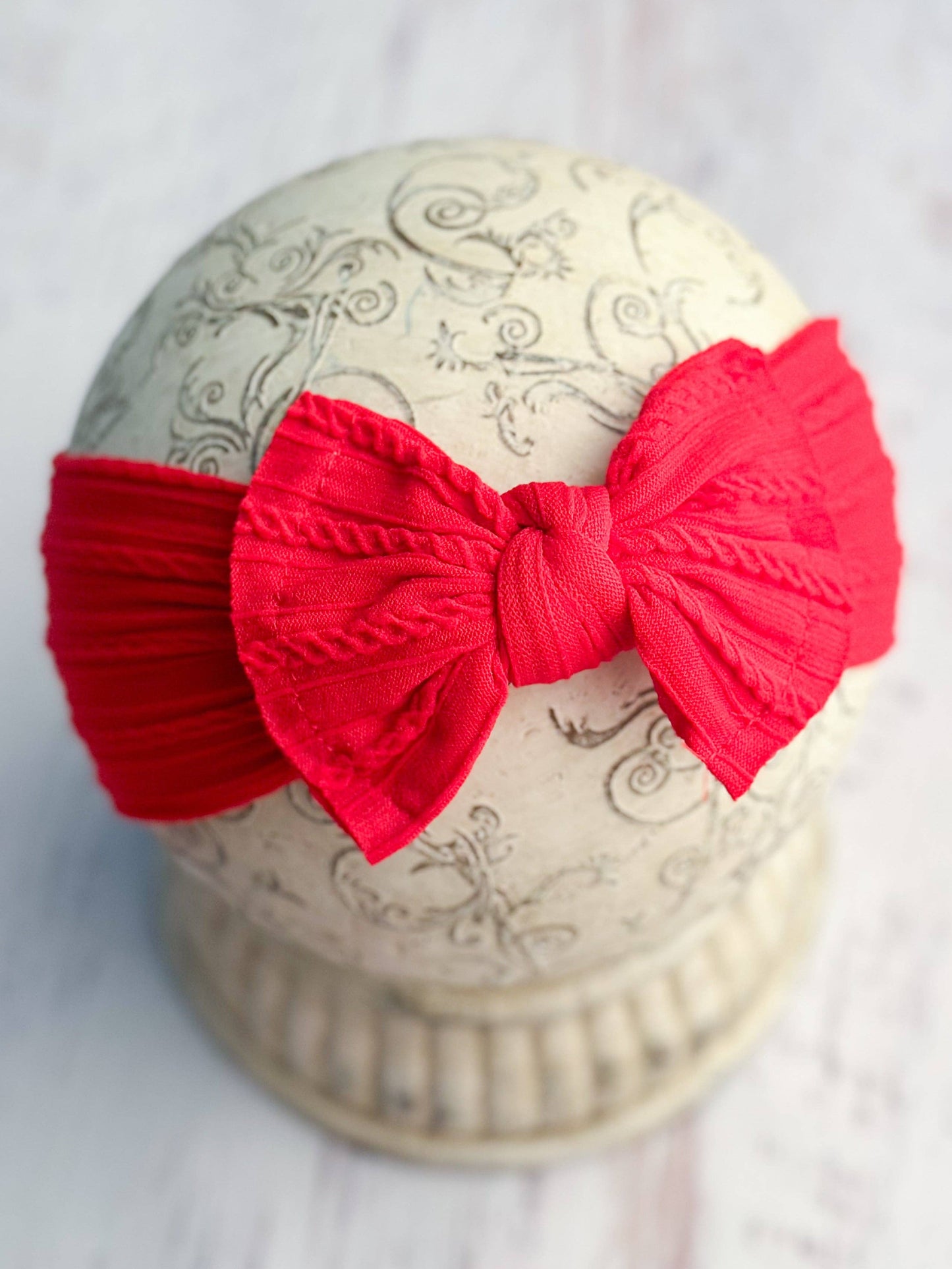 Red bow on a decorative white box with intricate patterns