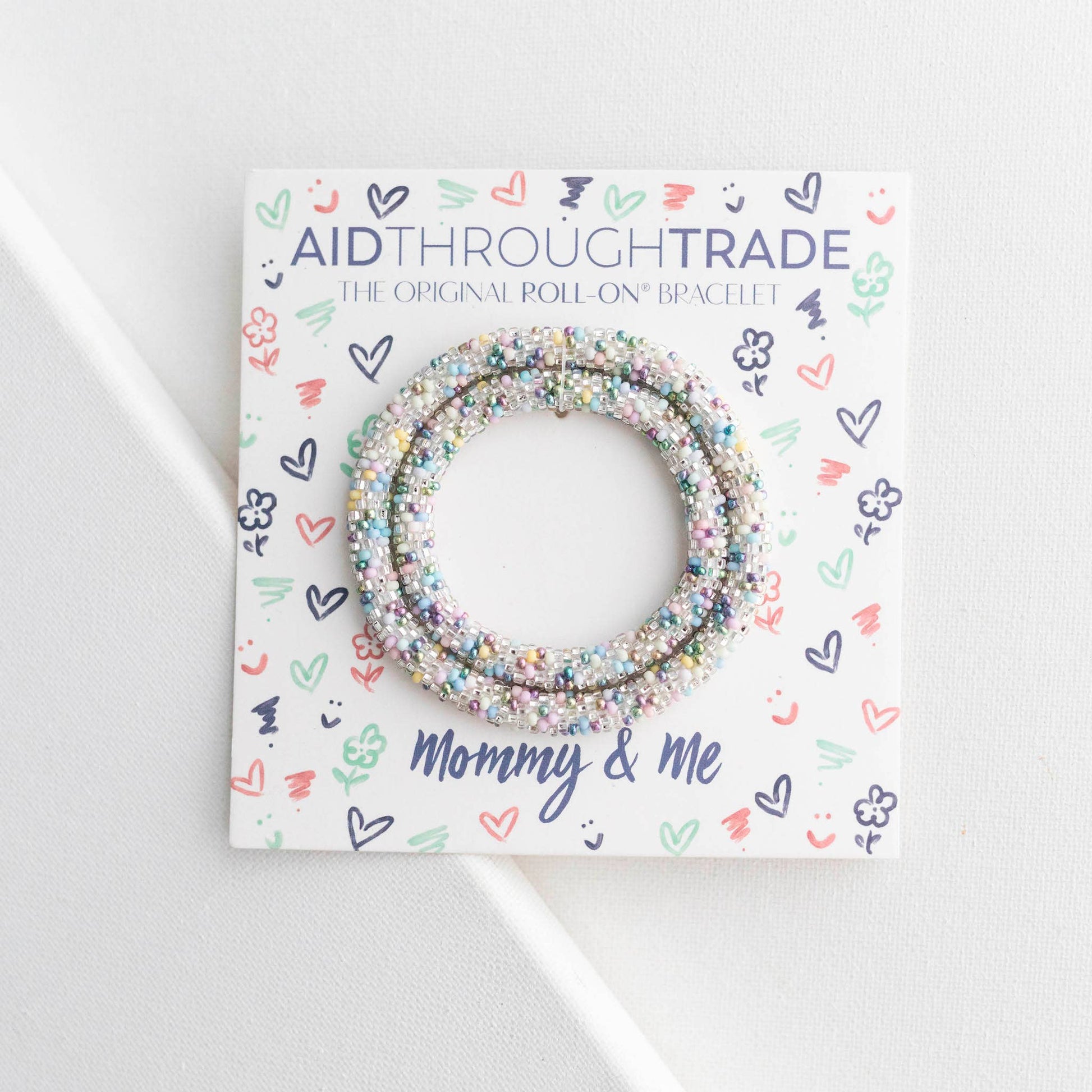 Bracelets on a 'Aid Through Trade' branded card with decorative patterns