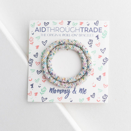 Bracelets on a 'Aid Through Trade' branded card with decorative patterns