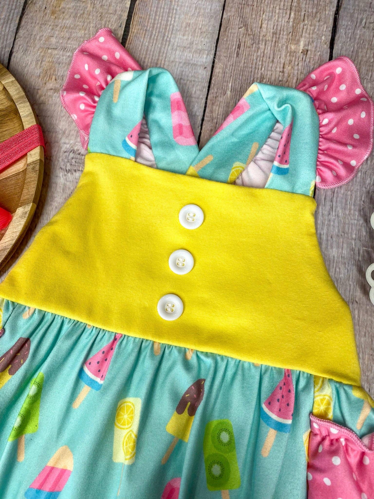 Colorful dress with ice cream pattern on a wooden surface