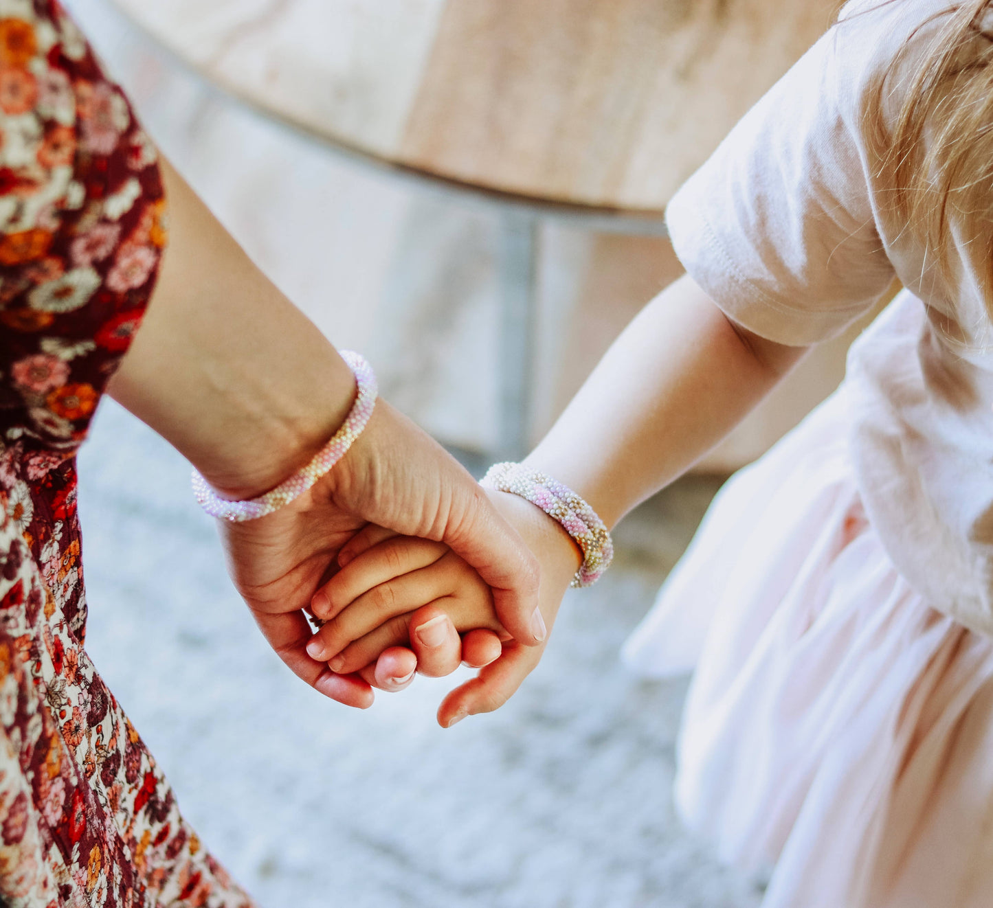 Two people holding hands with a blurred background