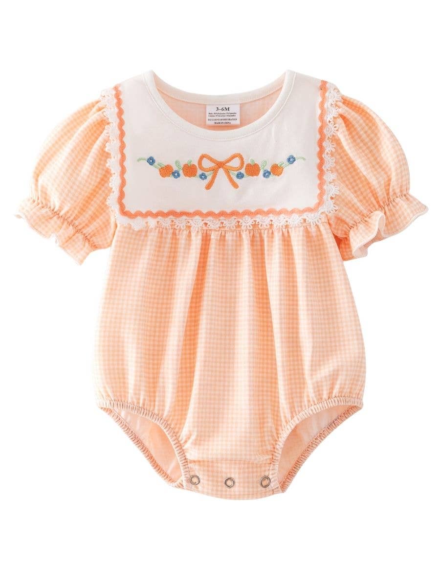 Baby romper with orange checkered pattern and white top on a white background