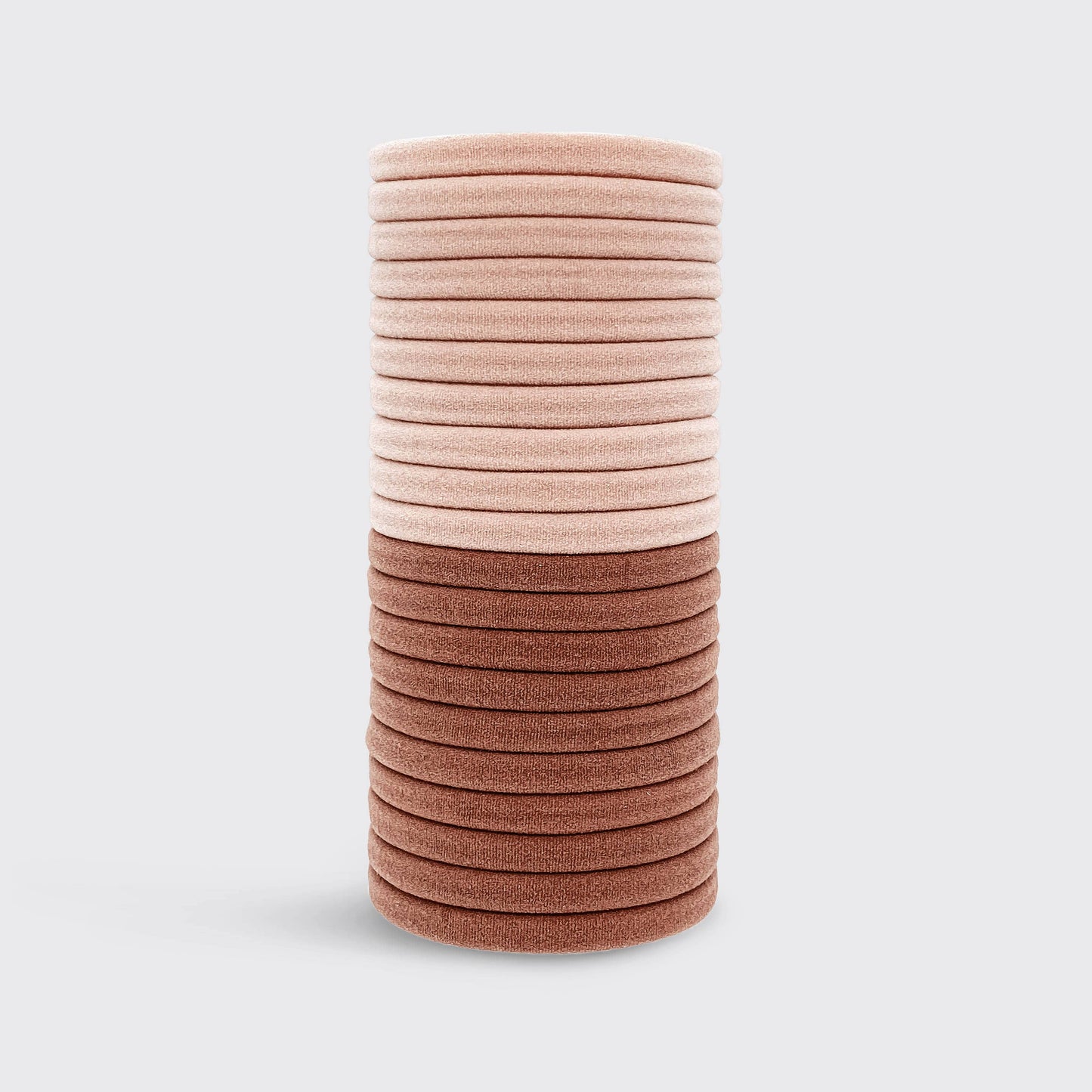 Stack of pink and brown hair ties on a light gray background