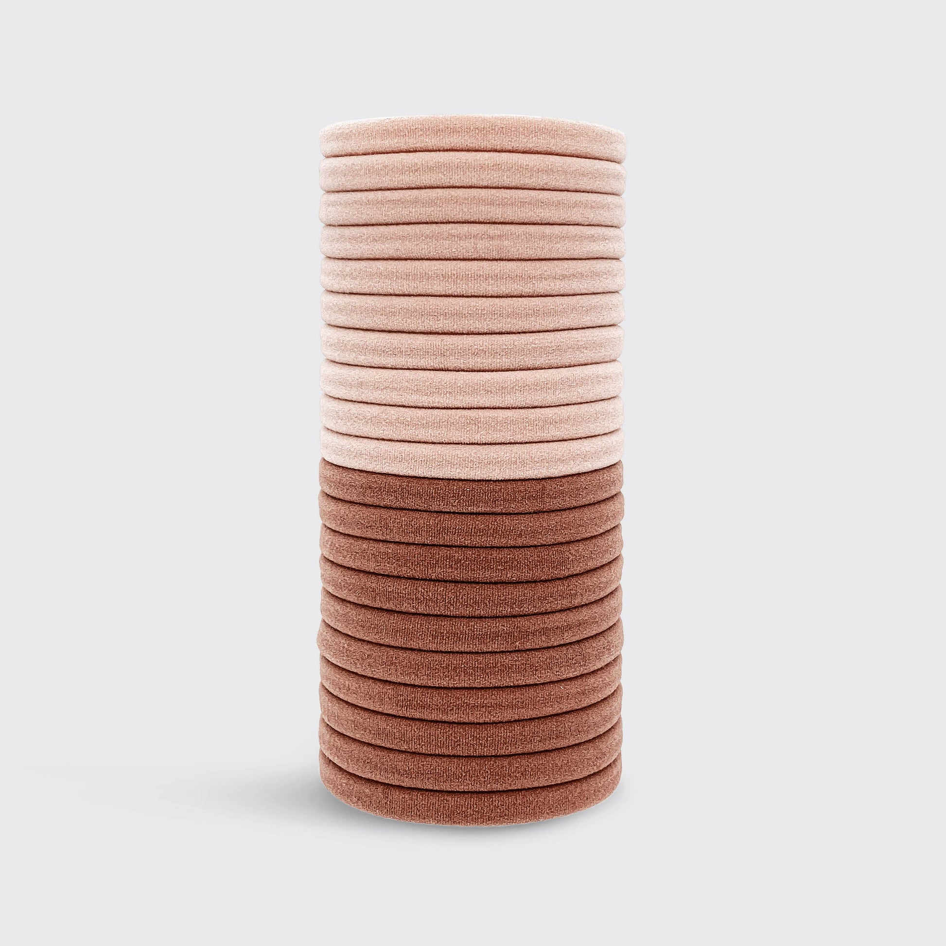 Stack of pink and brown hair ties on a light gray background
