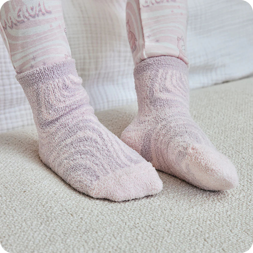 Pink fuzzy socks worn on a light surface